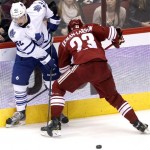 Toronto Maple Leafs center Tyler Bozak (42) and Phoenix Coyotes defenseman Oliver Ekman-Larsson (23) battle for the puck in the second period of an NHL hockey game, Monday, Jan. 20, 2014, in Glendale, Ariz. (AP Photo/Rick Scuteri)