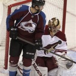 Phoenix Coyotes goalie Thomas Greiss, right, of Germany, gathers a shot as Colorado Avalanche left wing Patrick Bordeleau backs into the crease during the third period of an NHL hockey game in Denver on Tuesday, Dec. 10, 2013. Phoenix won 3-1. (AP Photo/Joe Mahoney)