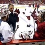 Phoenix Coyotes goalies Mike Smith, right, and Jason LaBarbera, left, talk with goaltending coach and assistant to the general manager Sean Burke during an NHL hockey practice, Tuesday, Jan. 15, 2013, in Glendale, Ariz. The NHL is scheduled to start its lockout-shortened season Jan. 19th. (AP Photo/Ross D. Franklin)