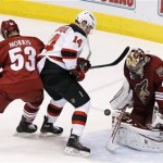 Phoenix Coyotes' Mike Smith (41) makes a save on a shot by New Jersey Devils' Adam Henrique (14) as Coyotes' Derek Morris (53) also defends in front of the goal during the second period of an NHL hockey game on Saturday, Jan. 18, 2014, in Glendale, Ariz. (AP Photo/Ross D. Franklin)