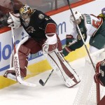 Phoenix Coyotes goalie Mike Smith, left, kicks the puck away from Minnesota Wild Mikael Granlund (64), of Finland, during the first period of an NHL hockey game, Monday, Feb. 4, 2013, in Glendale, Ariz. (AP Photo/Matt York)
