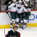 Minnesota Wild's Zach Parise, center, celebrates his goal with teammates Dany Heatley, right, and Mikko Koivu, of Finland, as Phoenix Coyotes' Mikkel Boedker (89), of Denmark, skates by during the second period of an NHL hockey game, Monday, Feb. 4, 2013, in Glendale, Ariz. (AP Photo/Matt York)
