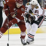 Phoenix Coyotes' Keith Yandle (3) tries to keep the puck away from Chicago Blackhawks' Marian Hossa (81) during the first period in an NHL hockey game, Friday Feb. 7, 2014, in Glendale, Ariz. (AP Photo/Ross D. Franklin)
