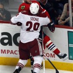 Phoenix Coyotes' Michael Stone (29) checks Chicago Blackhawks' Bryan Bickell into the boards during an NHL hockey game Saturday, Apr. 20, 2013, in Chicago. The Coyotes beat the Blackhawks 3-2 in a shootout. (AP Photo/John Smierciak)
