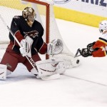 Phoenix Coyotes' Thomas Greiss, left, of Germany, makes a save on a shot by Calgary Flames' Lee Stempniak, right, during the second period of an NHL hockey game Tuesday, Jan. 7, 2014, in Glendale, Ariz. Phoenix defeated Calgary 6-0. (AP Photo/Ross D. Franklin)