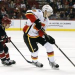Calgary Flames' Joe Colborne (8) skates with the puck in front of Phoenix Coyotes' David Moss (18) during the first period of an NHL hockey game, Tuesday, Jan. 7, 2014, in Glendale, Ariz. (AP Photo/Ross D. Franklin)