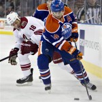 Phoenix Coyotes' David Moss (18) chases Edmonton Oilers' Jordan Eberle (14) during the first period of an NHL hockey game in Edmonton, Alberta, on Saturday, Feb. 23, 2013. (AP Photo/The Canadian Press, Jason Franson)
