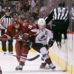 Phoenix Coyotes right winger David Moss, left, battles Colorado Avalanche left winger Gabriel Landeskog, right, of Sweden, for the loose puck as linesman Andy McElman, right, leaps out of the way in the first period of NHL hockey game, Saturday, April 6, 2013, in Glendale, Ariz. (AP Photo/Paul Connors)
