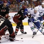Phoenix Coyotes' Mike Smith (41) makes as save on a shot by Vancouver Canucks' Alex Burrows (14) as Coyotes' Rostislav Klesla (16), of the Czech Republic, defends, while Coyotes' Martin Hanzal (11), of the Czech Republic, and Canucks' Chris Higgins, top right, both look on during the first period of an NHL hockey game on Tuesday, Nov. 5, 2013, in Glendale, Ariz. (AP Photo/Ross D. Franklin)
