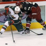 Minnesota Wild's Pierre-Marc Bouchard (96) passes the puck as Phoenix Coyotes' Kyle Chipchura defends during the second period of an NHL hockey game, Monday, Feb. 4, 2013, in Glendale, Ariz. (AP Photo/Matt York)
