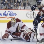  Phoenix Coyotes goaltender Mike Smith (41) stops a shot by Winnipeg Jets' James Wright (17) as Coyotes' Derek Morris (53) looks for the rebound during second-period NHL hockey game action in Winnipeg, Manitoba, Thursday, Feb. 27, 2014. (AP Phoyo/The Canadian Press, John Woods)