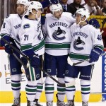Vancouver Canucks' Chris Tanev (8) celebrates his goal against the Phoenix Coyotes with teammates Mason Raymond (21), Cam Barker (18) and Jordan Schroeder (45) during the first period of an NHL hockey game on Thursday, March 21, 2013, in Glendale, Ariz. (AP Photo/Ross D. Franklin)