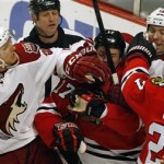Chicago Blackhawks' Johnny Oduya (27) hits Phoenix Coyotes' David Moss (18) in the face as the two teams mix it up next to the Blackhawks net during an NHL hockey game Saturday, Apr. 20, 2013, in Chicago. The Coyotes beat the Blackhawks 3-2 in a shootout. (AP Photo/John Smierciak)