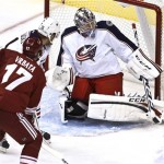 Columbus Blue Jackets' Steve Mason, right, makes a save on a shot by Phoenix Coyotes' Radim Vrbata (17), of the Czech Republic, as Blue Jackets' James Wisniewski, center, defends during the first period in an NHL hockey game on Wednesday, Jan. 23, 2013, in Glendale, Ariz. (AP Photo/Ross D. Franklin)