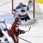 San Jose Sharks goalie Thomas Greiss, top, deflects a shot on-goal by Phoenix Coyotes' Alexandre Bolduc (49) as Sharks' Brad Stuart defends during the first period of an NHL hockey game on Wednesday, April 24, 2013, in Glendale, Ariz. (AP Photo/Matt York)