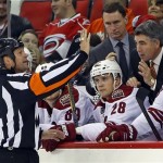 Phoenix Coyotes' head coach Dave Tippett, right, questions a call with referee Dan O'Halloran during the second period of an NHL hockey game against the Carolina Hurricanes, Sunday, Oct. 13, 2013, in Raleigh, N.C. Phoenix defeated Carolina 5-3. (AP Photo/Karl B DeBlaker)