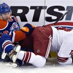 Phoenix Coyotes' David Moss (18) and Edmonton Oilers' Jordan Eberle (14) mix it up against the boards during the second period of an NHL hockey game in Edmonton, Alberta, on Saturday, Feb. 23, 2013. (AP Photo/The Canadian Press, Jason Franson)
