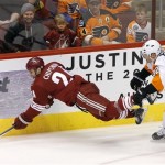 Philadelphia Flyers' Mark Streit (32), of Switzerland, checks Phoenix Coyotes' Kyle Chipchura (24) to the ice during the first period of an NHL hockey game Saturday, Jan. 4, 2014, in Glendale, Ariz. (AP Photo/Ross D. Franklin)