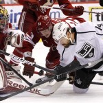 Los Angeles Kings' Justin Williams (14) battles with Phoenix Coyotes' Oliver Ekman-Larsson (23), of Sweden, and goalie Mike Smith, left, for the puck in the second period during Game 5 of the NHL hockey Stanley Cup Western Conference finals, Tuesday, May 22, 2012, in Glendale, Ariz. (AP Photo/Ross D. Franklin)