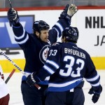 Winnipeg Jets' Olli Jokinen (12) celebrates with Dustin Byfuglien (33) after he scored his 12th goal of the season while playing against the Phoenix Coyotes' during first period NHL hockey action in Winnipeg, Monday, Jan. 13, 2014. (AP Photo/The Canadian Press, Trevor Hagan)
