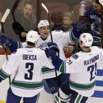 Vancouver Canucks' Jordan Schroeder (45) celebrates his goal against the Phoenix Coyotes with teammates Kevin Bieksa (3), and Mason Raymond (21) during the third period in an NHL hockey game, Thursday, March 21, 2013, in Glendale, Ariz. The Canucks defeated the Coyotes 2-1. (AP Photo/Ross D. Franklin)