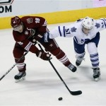 Phoenix Coyotes right wing Shane Doan (19) and Toronto Maple Leafs defenseman Jake Gardiner (51) battle for the puck in the third period during an NHL hockey game, Monday, Jan. 20, 2014, in Glendale, Ariz. (AP Photo/Rick Scuteri)
