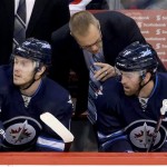 Winnipeg Jets head coach Paul Maurice talks with Bryan Little (18) and Andrew Ladd (16) during first period NHL hockey action against the Phoenix Coyotes in Winnipeg, Canada, Monday, Jan. 13, 2014. (AP Photo/The Canadian Press, Trevor Hagan)
