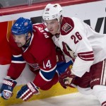 Montreal Canadiens' Tomas Plekanec is squeezed against the boards by Phoenix Coyotes defenseman Michael Stone during the third period of an NHL hockey game Tuesday, Dec. 17, 2013, in Montreal. Montreal won 3-1. (AP Photo/The Canadian Press, Paul Chiasson)