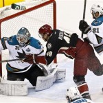 San Jose Sharks' Antti Niemi (31), of Finland, makes a save on a shot by Phoenix Coyotes' Alex Bolduc (49) as he is shoved by Sharks' T.J. Galiardi (21) in the second period during an NHL hockey game, on Monday, April 15, 2013 in Glendale, Ariz. The Sharks defeated the Coyotes 4-0. (AP Photo/Ross D. Franklin)