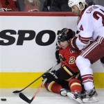 Calgary Flames' Jiri Hudler, left, from Czech Republic, plays the puck against Phoenix Coyotes' Kyle Chipchura during the third period of an NHL hockey game in Calgary, Alberta, Friday April 12, 2013. (AP Photo/The Canadian Press, Larry MacDougal)