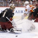 Phoenix Coyotes' Thomas Greiss (1), of Germany, makes a save on a shot by Calgary Flames' Paul Byron (32) as Coyotes' David Schlemko, right, defends during the first period of an NHL hockey game, Tuesday, Jan. 7, 2014, in Glendale, Ariz. (AP Photo/Ross D. Franklin)