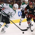  Dallas Stars' Cody Eakin, left, tries to control the puck in front of Phoenix Coyotes' Kyle Chipchura, right, during the second period of an NHL hockey game, Tuesday, Feb. 4, 2014, in Glendale, Ariz. (AP Photo/Ross D. Franklin)