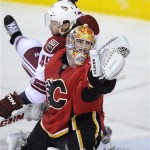 Calgary Flames goalie Joey MacDonald, right, makes a save despite being bumped by Phoenix Coyotes' Alexandre Bolduc during second-period NHL hockey game action in Calgary, Alberta, Friday, April 12, 2013. (AP Photo/The Canadian Press, Larry MacDougal)