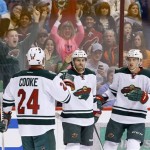 Minnesota Wild's Justin Fontaine, middle, celebrates his goal against the Phoenix Coyotes with teammates Matt Cooke (24) and Jonas Brodin, of Sweden, during the first period in an NHL hockey game Thursday, Jan. 9, 2014, in Glendale, Ariz. (AP Photo/Ross D. Franklin)