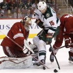Phoenix Coyotes' Mike Smith, left, makes a save on a shot by Minnesota Wild's Dany Heatley, of Germany, as Coyotes' David Moss (18) defends during the first period in an NHL hockey game Thursday, Jan. 9, 2014, in Glendale, Ariz. (AP Photo/Ross D. Franklin)
