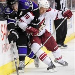 Los Angeles Kings center Anze Kopitar, left, of Slovenia, and Phoenix Coyotes left wing David Moss (18) battle for the puck during the second period of an NHL hockey game, Monday, March 18, 2013, in Los Angeles. (AP Photo/Gus Ruelas)