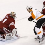 Phoenix Coyotes' Mike Smith, left, makes a save on a shot by Philadelphia Flyers' Steve Downie (9) as Coyotes' Rostislav Klesla (16), of the Czech Republic, defends during the first period of an NHL hockey game Saturday, Jan. 4, 2014, in Glendale, Ariz. (AP Photo/Ross D. Franklin)