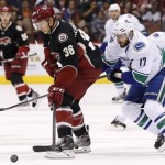 Phoenix Coyotes' Rob Klinkhammer (36) tries to keep the puck away from Vancouver Canucks' Ryan Kesler (17) during the first period of an NHL hockey game on Tuesday, Nov. 5, 2013, in Glendale, Ariz. (AP Photo/Ross D. Franklin)