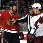 An official separates Chicago Blackhawks' Bryan Bickell, left, and Phoenix Coyotes' Shane Doan during the first period of an NHL hockey game Saturday, April 20, 2013, in Chicago. (AP Photo/John Smierciak)