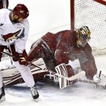 Phoenix Coyotes goalie Mike Smith, right, makes a save on a shot by Paul Bissonnette during an NHL hockey practice, Tuesday, Jan. 15, 2013, in Glendale, Ariz. (AP Photo/Ross D. Franklin)