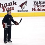 An advertisement shows an appreciation for the fans as Phoenix Coyotes head coach Dave Tippett watches his players during an NHL hockey practice, Tuesday, Jan. 15, 2013, in Glendale, Ariz. (AP Photo/Ross D. Franklin)