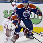 Edmonton Oilers' Nick Schultz (15) checks Phoenix Coyotes' David Moss (18) during the second period of an NHL hockey game in Edmonton, Alberta, on Saturday, Feb. 23, 2013. (AP Photo/The Canadian Press, Jason Franson)
