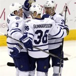 Toronto Maple Leafs defenseman Carl Gunnarsson (36) celebrates with Dion Phaneuf (3) and Carter Ashton (37) after scoring a second period goal against the Phoenix Coyotes during an NHL hockey game, Monday, Jan. 20, 2014, in Glendale, Ariz. (AP Photo/Rick Scuteri)