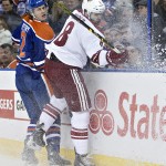 Arizona Coyotes' Tobias Rieder (8) is checked by Edmonton Oilers' Jeff Petry (2) during the first period of an NHL hockey game in Edmonton, Alberta, Tuesday, Dec. 23, 2014. (AP Photo/The Canadian Press, Jason Franson)

