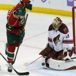 Minnesota Wild's Charlie Coyle, left, jumps clear for a teammate's shot as Arizona Coyotes goalie Mike Smith stops it during the first period of an NHL hockey game, Thursday, Oct. 23, 2014, in St. Paul, Minn. (AP Photo/Jim Mone)
