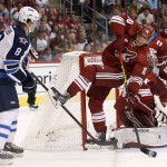 Arizona Coyotes' Martin Erat (10), of the Czech Republic, gets tripped up by Winnipeg Jets' Jacob Trouba (8) during the first period of an NHL hockey game Thursday, Oct. 9, 2014, in Glendale, Ariz. The Coyotes' Erat was called for a delay of game penalty on the play. (AP Photo/Ross D. Franklin)