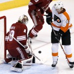 Arizona Coyotes' Devan Dubnyk, left, makes a save on a shot as Philadelphia Flyers' Vincent Lecavalier, right, looks on during the first period of an NHL hockey game Monday, Dec. 29, 2014, in Glendale, Ariz. (AP Photo/Ross D. Franklin)
