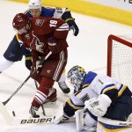 St. Louis Blues' Brian Elliott (1) makes a save on a shot by Arizona Coyotes' Shane Doan, middle, as Blues' Jay Bouwmeester defends during the third period of an NHL hockey game Tuesday, Jan. 6, 2015, in Glendale, Ariz. The Blues defeated the Coyotes 6-0. (AP Photo/Ross D. Franklin)