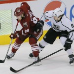 Arizona Coyotes left wing Mikkel Boedker (89) and Los Angeles Kings defenseman Drew Doughty (8) battle for the puck in the third period during an NHL hockey game, Thursday, Dec. 4, 2014, in Glendale, Ariz. (AP Photo/Rick Scuteri)
