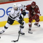 Los Angeles Kings right wing Dustin Brown (23) and Arizona Coyotes center Sam Gagner (9) battle for the puck in the second period during an NHL hockey game, Thursday, Dec. 4, 2014, in Glendale, Ariz. (AP Photo/Rick Scuteri)